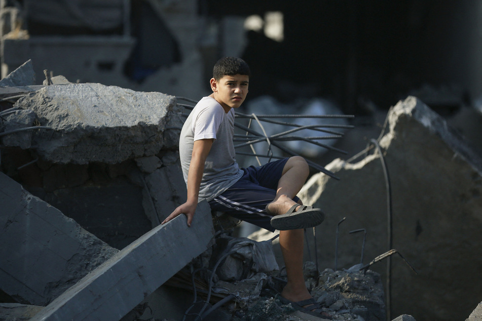 Ein Junge sitzt zwischen den Trümmern seines Zuhauses. Die Opferzahlen aus Dschabalia steigen beinahe minütlich an.