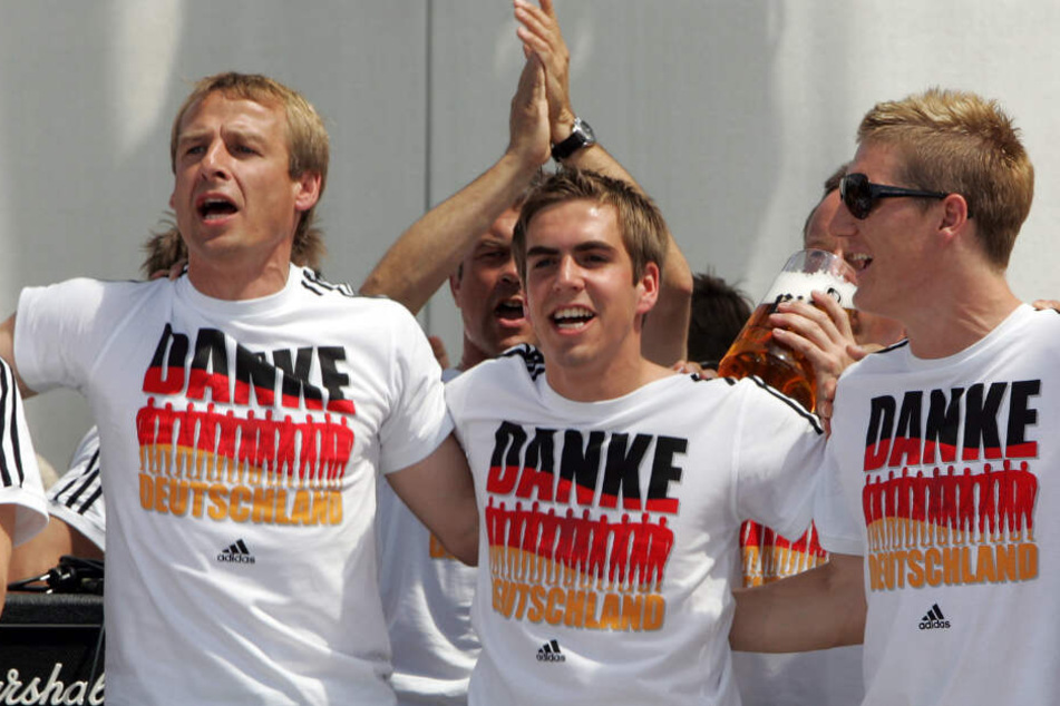 Die deutschen feiern die Vize-Weltmeisterschaft: Ex-Bundestrainer Jürgen Klinsmann (l.), Philipp Lahm (Mitte) und Bastian Schweinsteiger (r.).