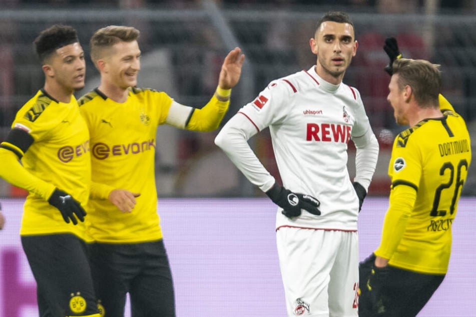 Kölns Ellyes Skhiri ist enttäuscht, während im Hintergrund v.li. Dortmunds Jadon Sancho, Dortmunds Marco Reus und Dortmunds Lukasz Piszczek das Tor zum 2:0 feiern.