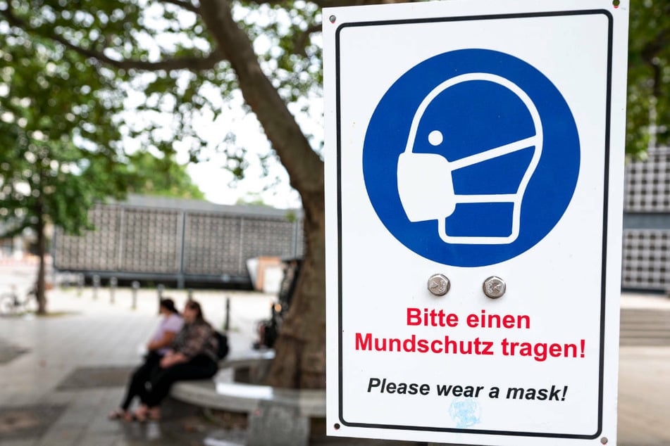 Ein Schild mit der Aufschrift «Bitte einen Mundschutz tragen!» hängt am Kurfürstendamm. Die Corona-Zahlen in Berlin steigen.