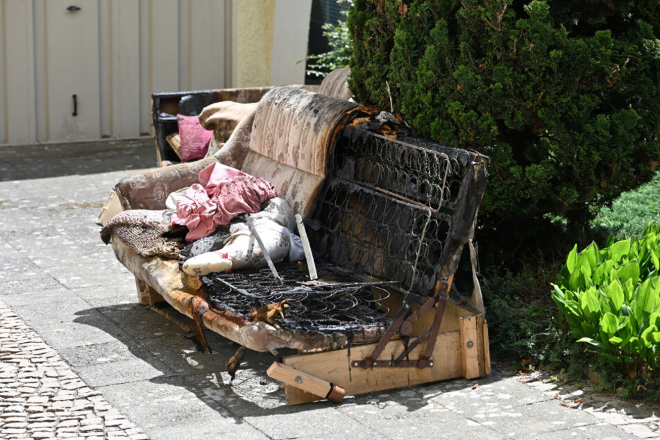 Die verkohlten Überreste des Sofas aus der Brandwohnung kehrte die Nachbarschaft am Sonntag zusammen.