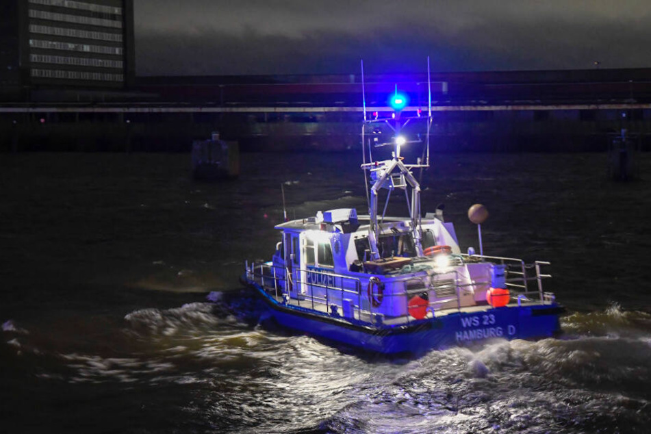 Ein Polizeiboot sucht mit Scheinwerferlicht die Elbe nach dem Vermissten ab.