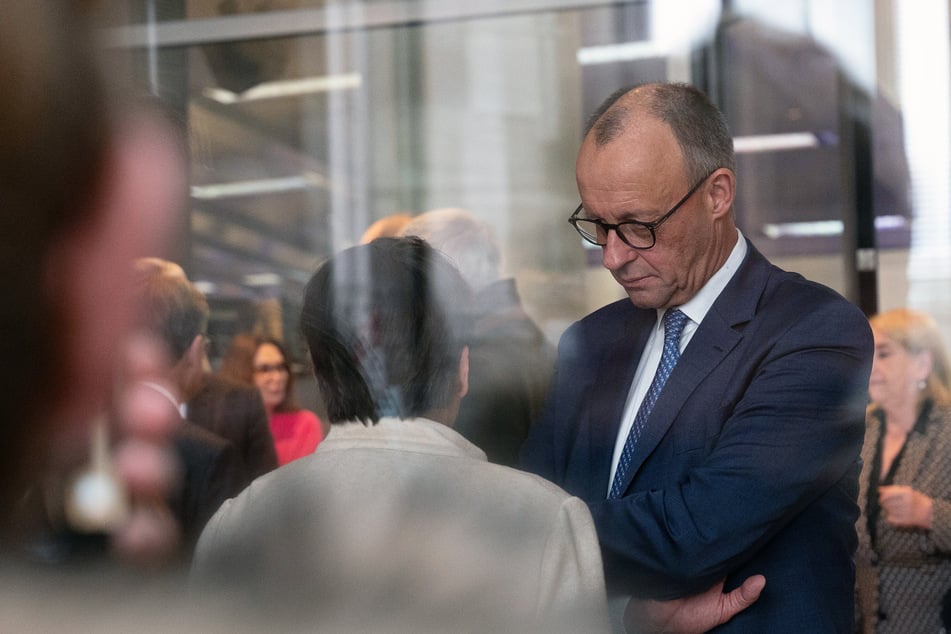 Bundeskanzler Friedrich Merz (r, CDU) im Gespräch mit Bundestagsabgeordneten.