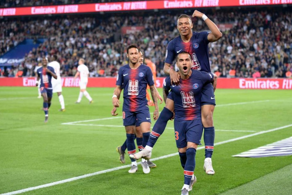 Dani Alves trägt Kylian Mbappé auf Schultern, links daneben schaut Neymar zu.