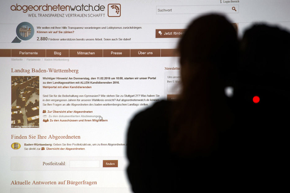 Eine Kameramann steht am 11.02.2016 in Stuttgart während einer Pressekonferenz vor einer Projektion des Internet-Portals abgeordnetenwatch.de.