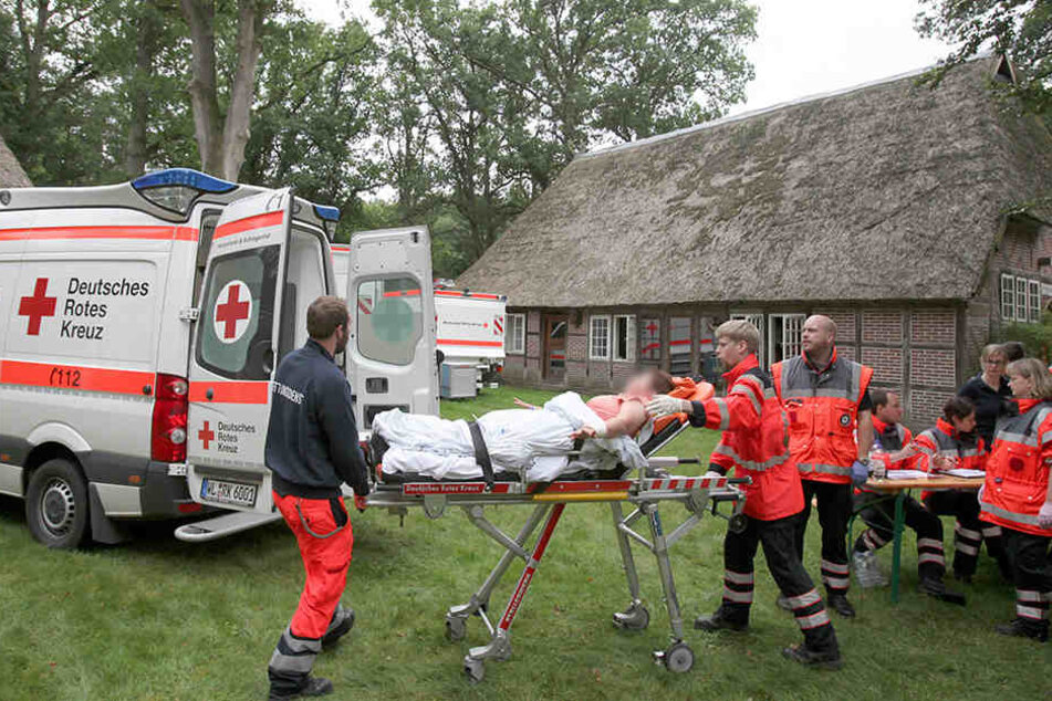 Eine verletzte Person wird auf einer Trage von Sanitätern zum Rettungsfahrzeug gebracht.