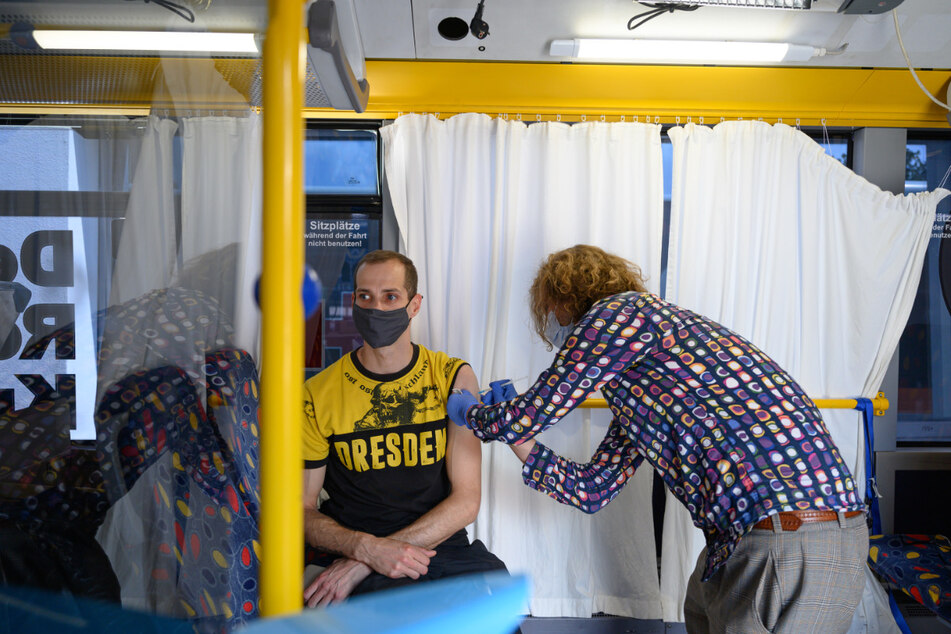 Ein Dynamofan lässt sich vor dem Hygienemuseum in Dresden in einem sogenannten Impfbus gegen das Coronavirus immunisieren.