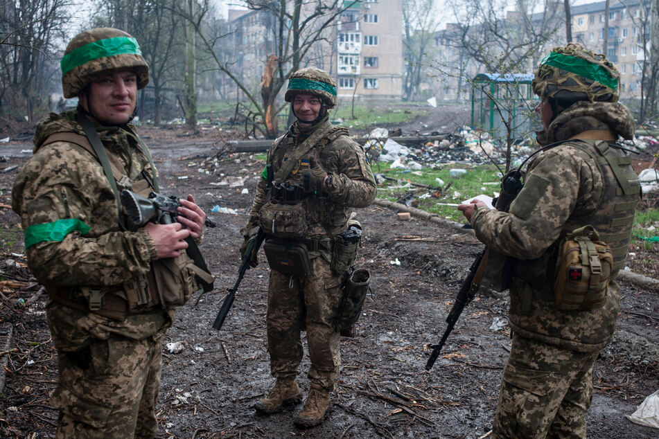 Bachmut: Ukrainische Soldaten unterhalten sich auf der Straße in der vom Krieg betroffenen Stadt.