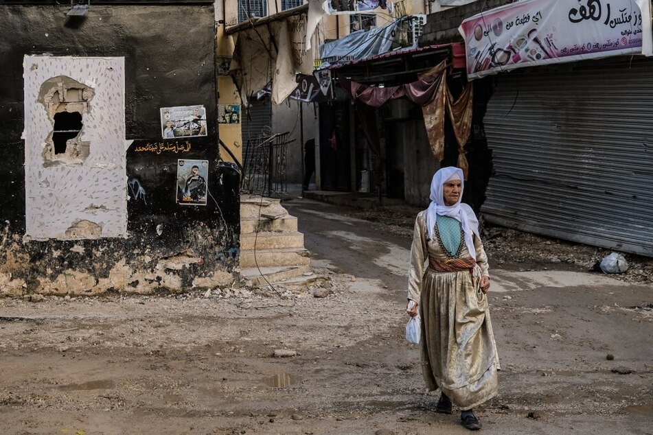 A woman walks on a damaged street in the Jenin refugee camp in the occupied West Bank.