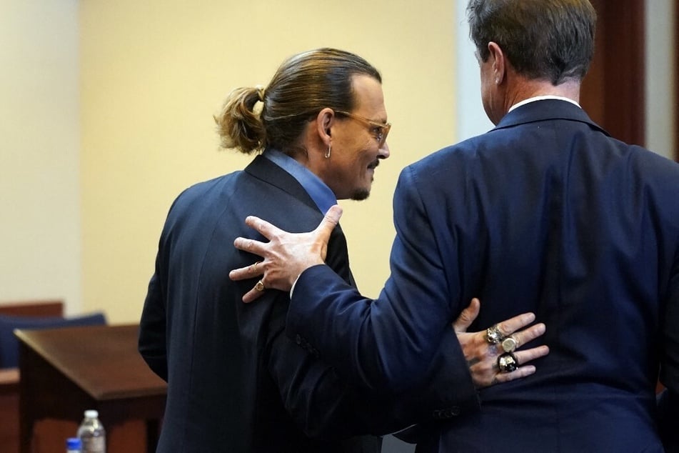 Johnny Depp embraces his attorney Benjamin Chew after closing arguments in Fairfax, Virginia, on May 27, 2022.