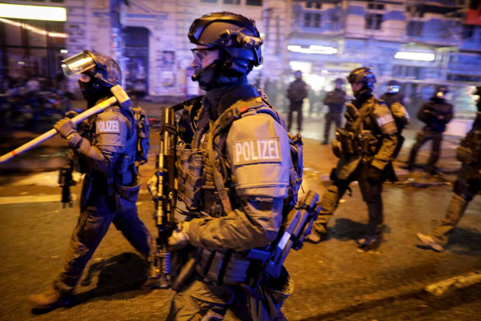 Schwer bewaffnete Spezial-Einsatzkräfte der Polizei laufen durch das Schanzenviertel.