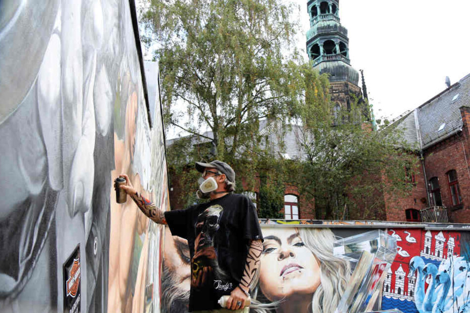 Streetart-Künstler Jens "Tasso" Müller greift noch einmal zur Spraydose, um das 130 Quadratmeter große Graffiti mit Blick auf den Dom in Zwickau fertigzustellen.