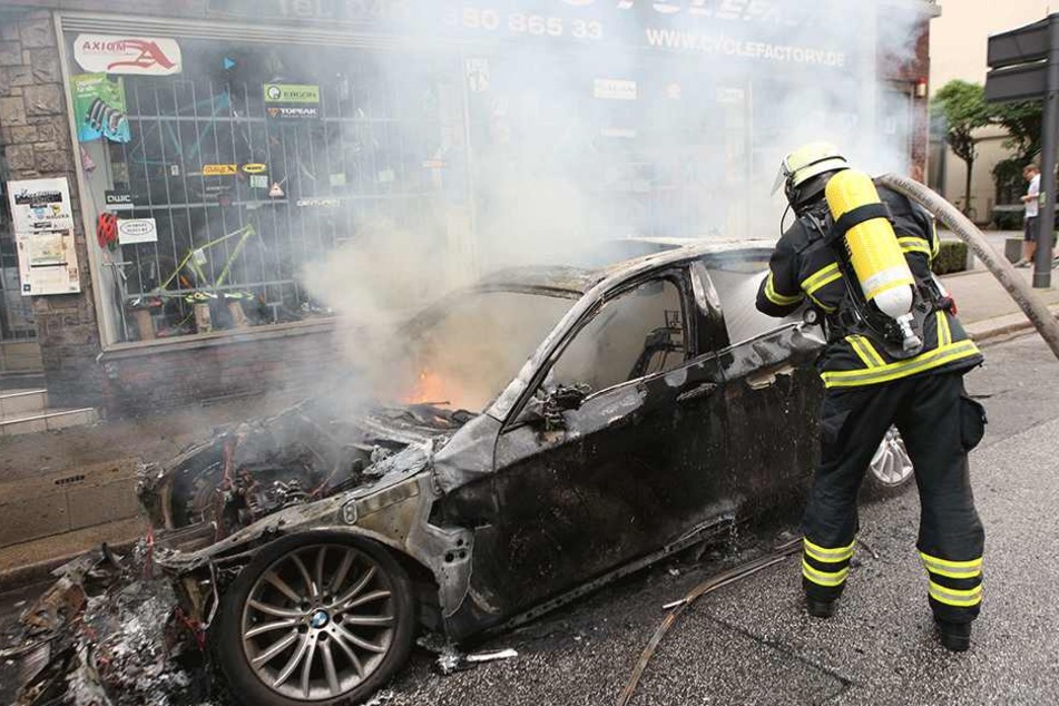 Hier kommt jede Hilfe zu spät: Ein Feuerwehrmann kann in Hamburg nur noch das ausgebrannte Wrack eines Autos löschen.