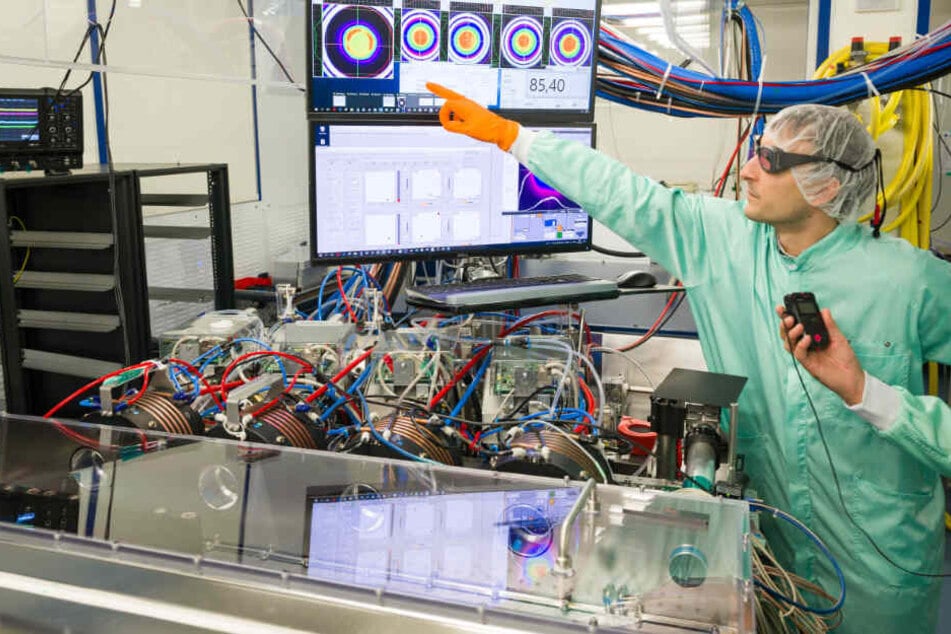 Ein Promotionsstudent der Firma Trumpf Scientific Lasers, erklärt die verschiedenen Stufen des Lasers.
