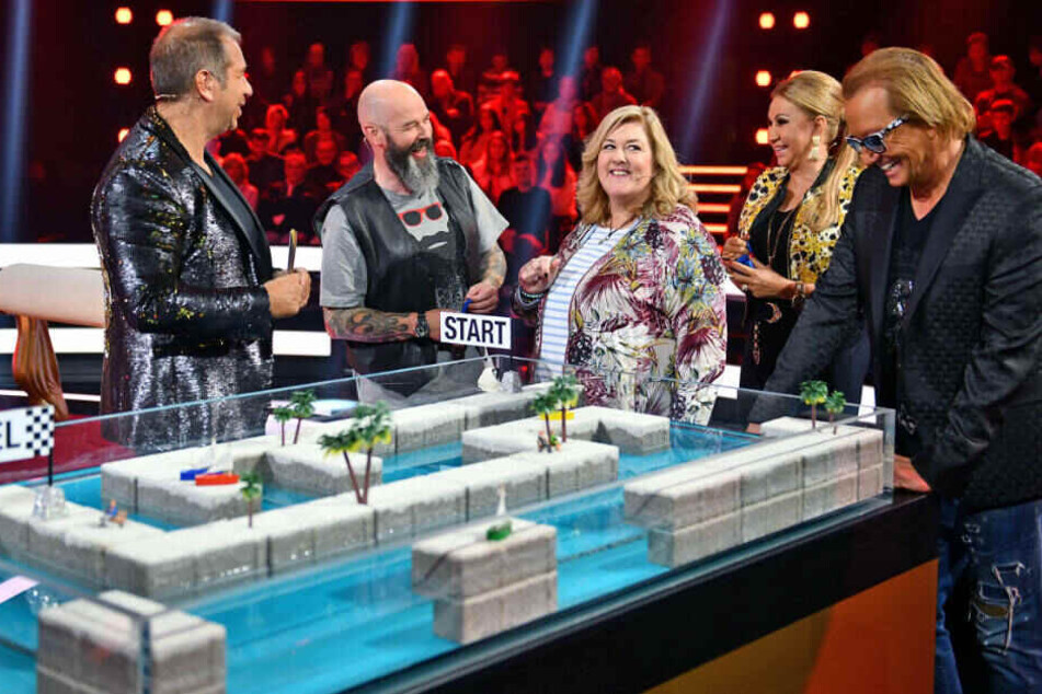 Moderator Kai Ebel mit den Kandidaten Kurt und Angelika sowie den Geissens.