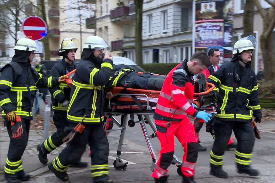 Der verletzte Feuerwehrmann wurde mit einer Trage abtransportiert und von einem Notarzt behandelt.