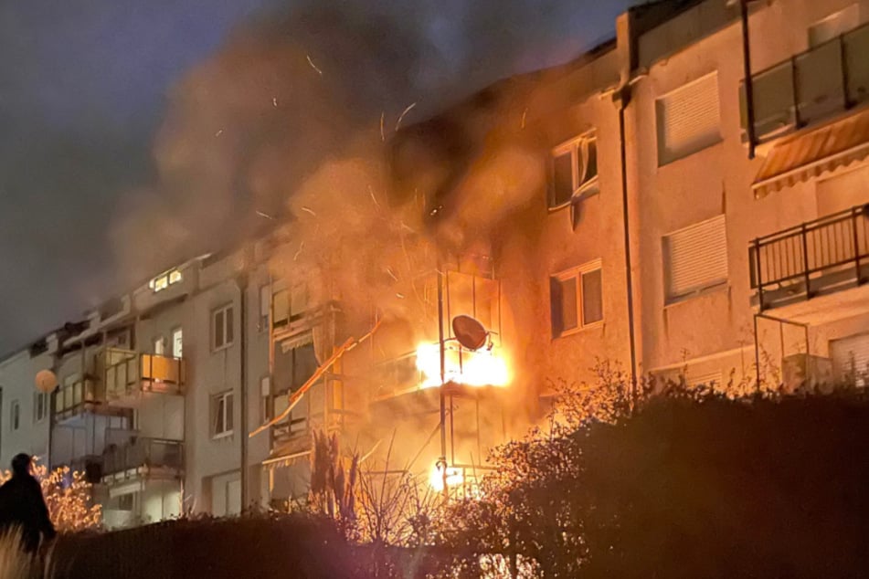 Die Flammen schlagen aus dem Balkon des Mehrfamilienhauses.