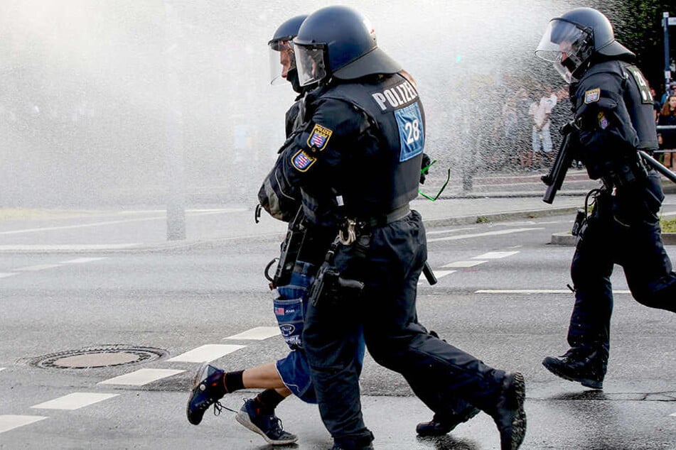 Polizisten nehmen am Pferdemarkt in Hamburg eine Person während eines Wasserwerfereinsatzes in Gewahrsam.