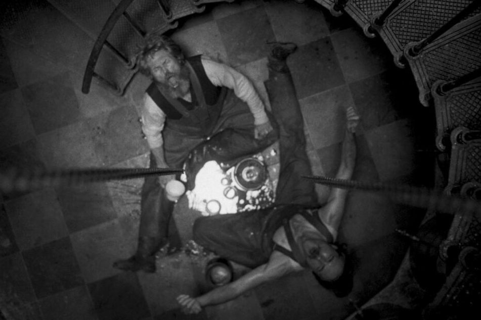 Die Einsamkeit und der anhaltende Sturm treiben Thomas Wake (l., Willem Dafoe) und Ephraim Winslow (Robert Pattinson) langsam in den Wahnsinn.