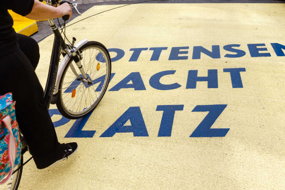 "Ottensen macht Platz" steht auf einem Asphalt-Schweller auf der Ottensener Hauptstraße.