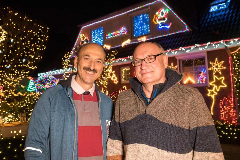 Die Nachbarn Stephan Kalkreuter (l) und Uwe Farkas stehen vor ihrem weihnachtlich geschmückten Haus.