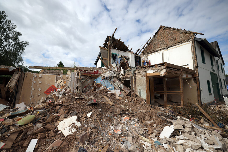 In Gemünd (Eifel) liegen Schutt und Geröll eines völlig zerstörten Hauses auf der Straße.