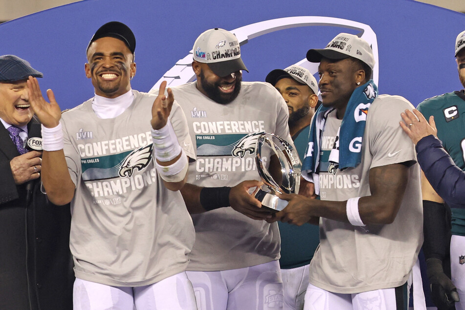 Philadelphia Eagles quarterback Jalen Hurts, defensive tackle Fletcher Cox, and wide receiver A.J. Brown celebrate during the NFC Championship trophy presentation after their win against the San Francisco 49ers.