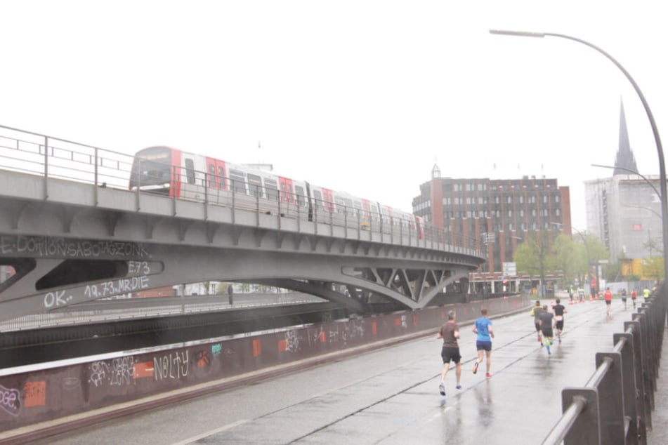 Neben der Linie U3 am Baumwall kämpfen sich die Läufer durch den Regen.
