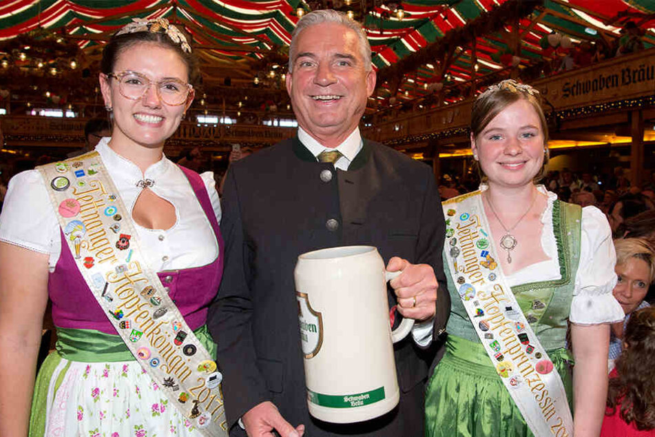 Innenminister Thomas Strobl (CDU) mit der Tettnanger Hopfenkönigin Teresa Locher (l.) und der Tettnanger Hopfenprinzessin Lena Heilig (r.) bei der Eröffnungsfeier des 173. Cannstatter Volksfest.