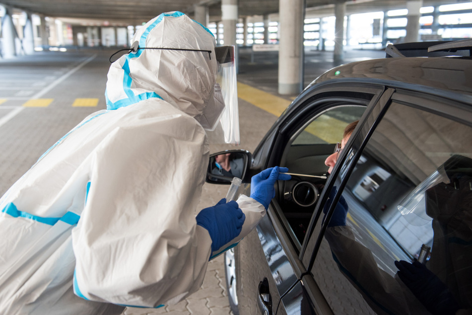 Im neuen Drive-Through-Corona-Testzentrum am Hamburger Flughafen wird ein Abstrich genommen.