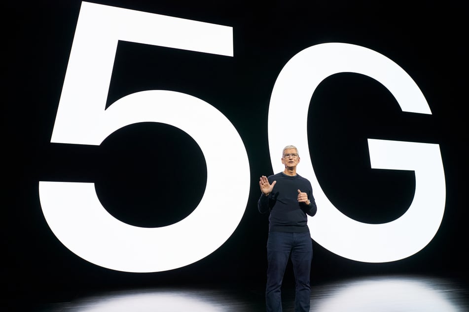 Tim Cook, Chef (CEO) von Apple, vor einem 5G-Schriftzug.