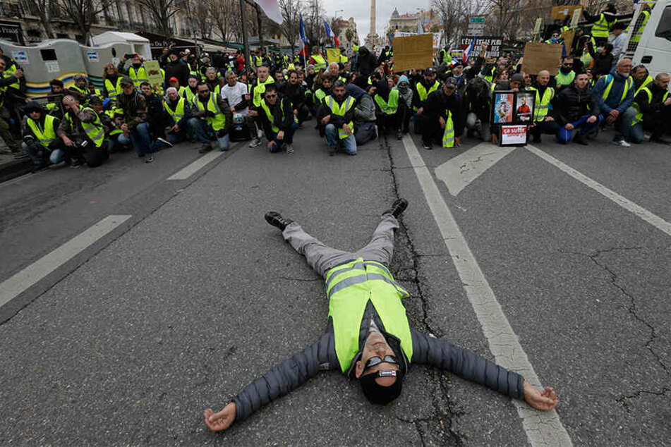Ein Demonstrant liegt bei einem Protest der "Gelbwesten" in Marseille auf einer Straße.