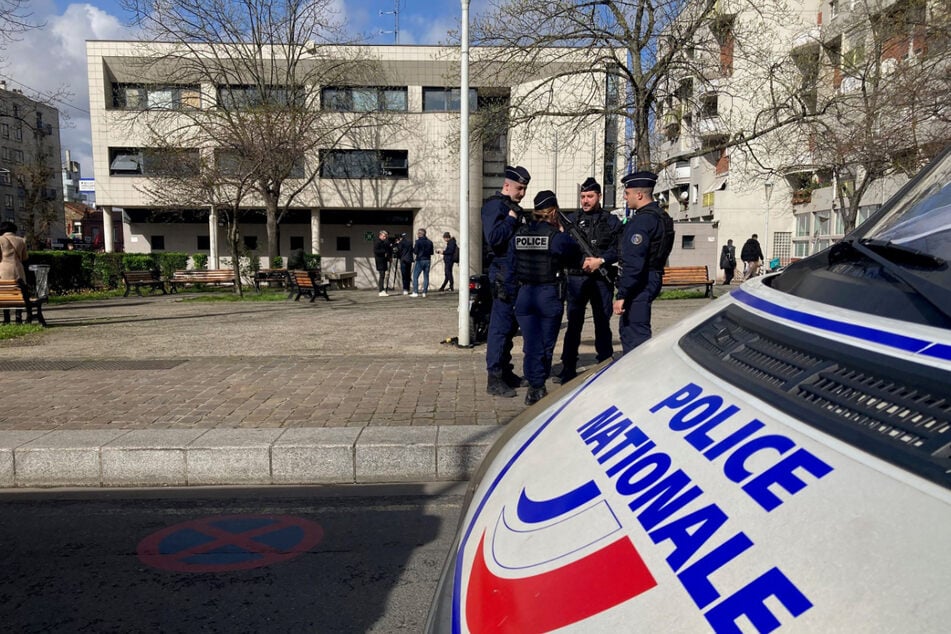 Einsatzkräfte stehen vor einem Polizeirevier in einem nördlichen Vorort von Paris.
