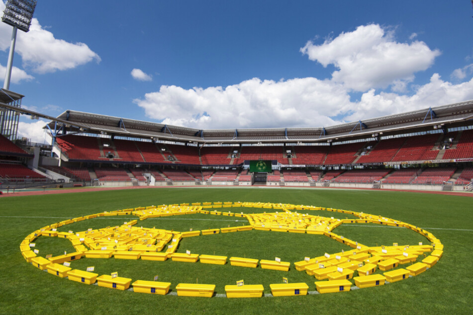 Künstler haben 350 gelbe Blumenkästen auf dem Rasen des Max-Morlock-Stadions zu einem Kunstwerk in Form eines Fußballs aufgebaut.