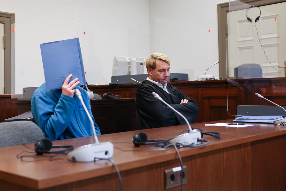 Der Angeklagte sitzt neben seinem Anwalt Philipp Naumann (r.) zu Beginn eines Prozesses im Strafjustizgebäude.