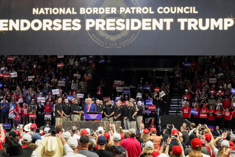 Republican presidential nominee Donald Trump speaks as members of National Border Patrol Council stand beside him during a campaign rally in Prescott Valley, Arizona.