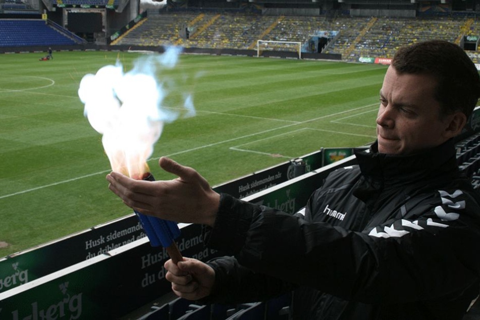 Der Fanbeauftragte von Bröndby Kopenhagen, Lasse Bauer, zeigt, wie ungefährlich die neuen Bengalos sind.