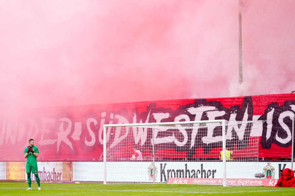 Kaiserslauterns Torwart Lennart Grill betrachtet den dichten weiß-roten Rauch auf Kaiserslauterns Westkurve im Hinspiel gegen Waldhof Mannheim.