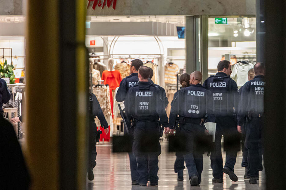 Polizeibeamte durchsuchen das geräumte Einkaufszentrum in Duisburg.