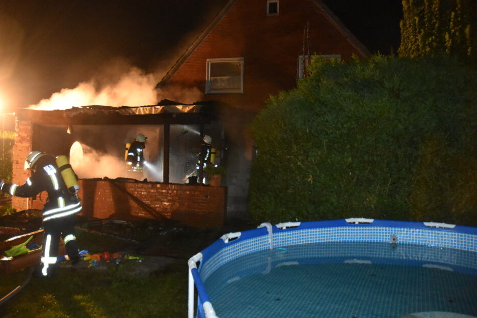 Feuerwehrleute versuchen den Wohnhausbrand in Fredenbeck einzudämmen.