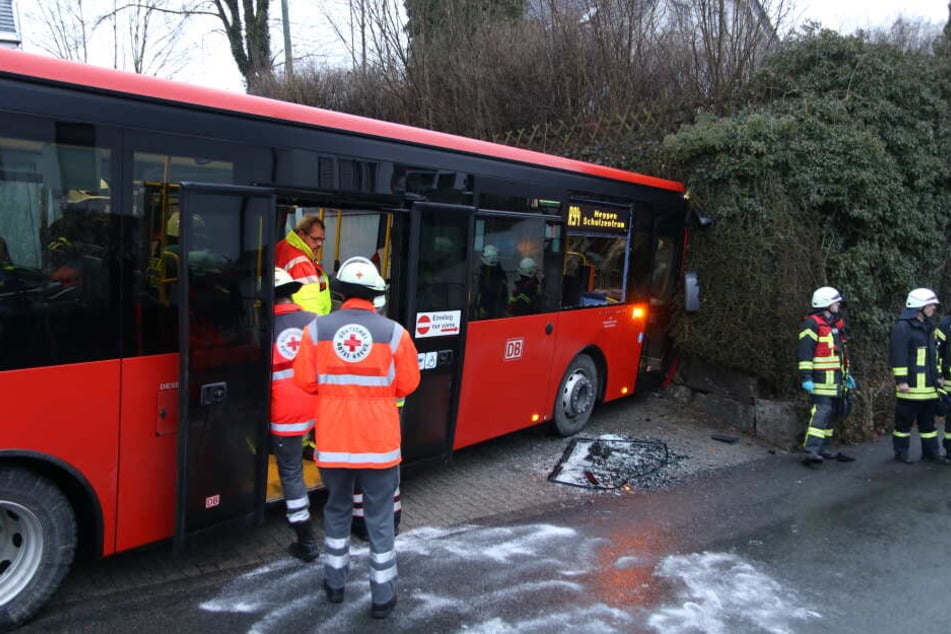 Ein Schulbus steht nach einem Unfall vor einer Mauer.