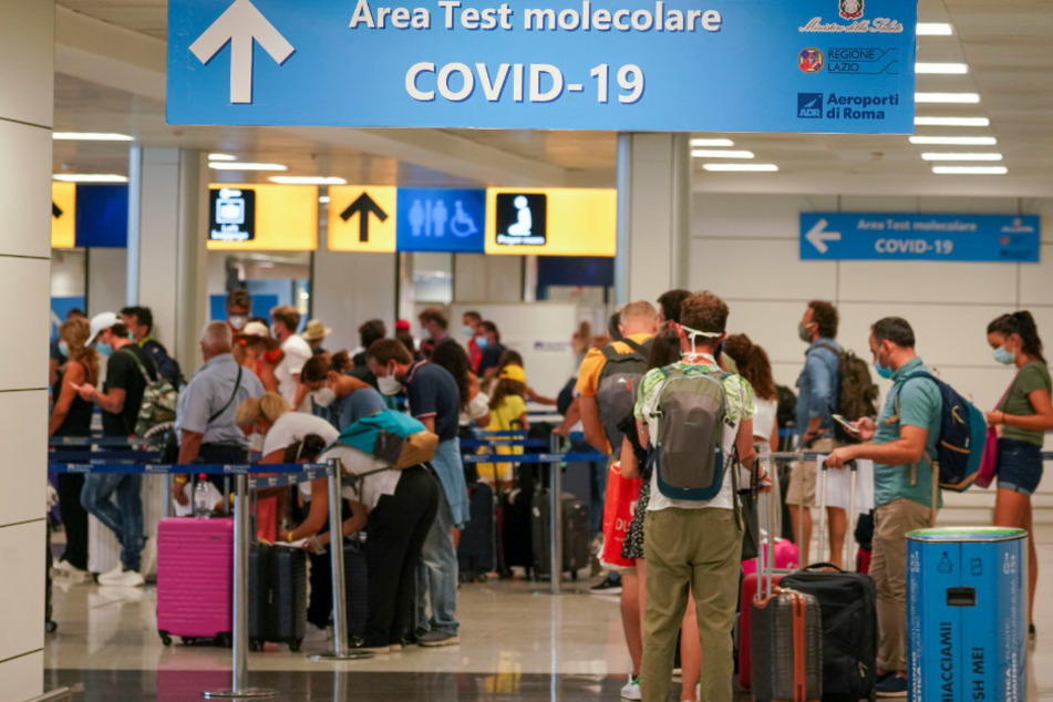 Rom: Urlauber stehen im Flughafen in einer Schlange für einen Covid-19-Test. Für alle Reisende, die aus Kroatien, Griechenland, Malta oder Spanien nach Italien einreisen, ist ein Covid-19-Test obligatorisch.