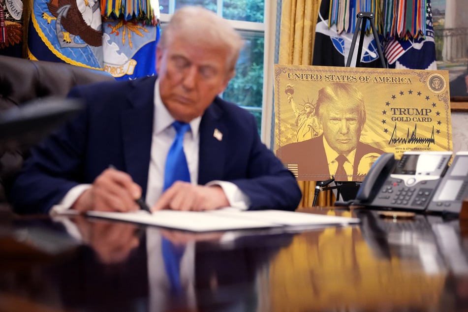 President Donald Trump signs a series of executive orders establishing the "Trump Gold Card" and introducing a $100,000 fee for H-1B visas in the Oval Office of the White House on September 19, 2025.