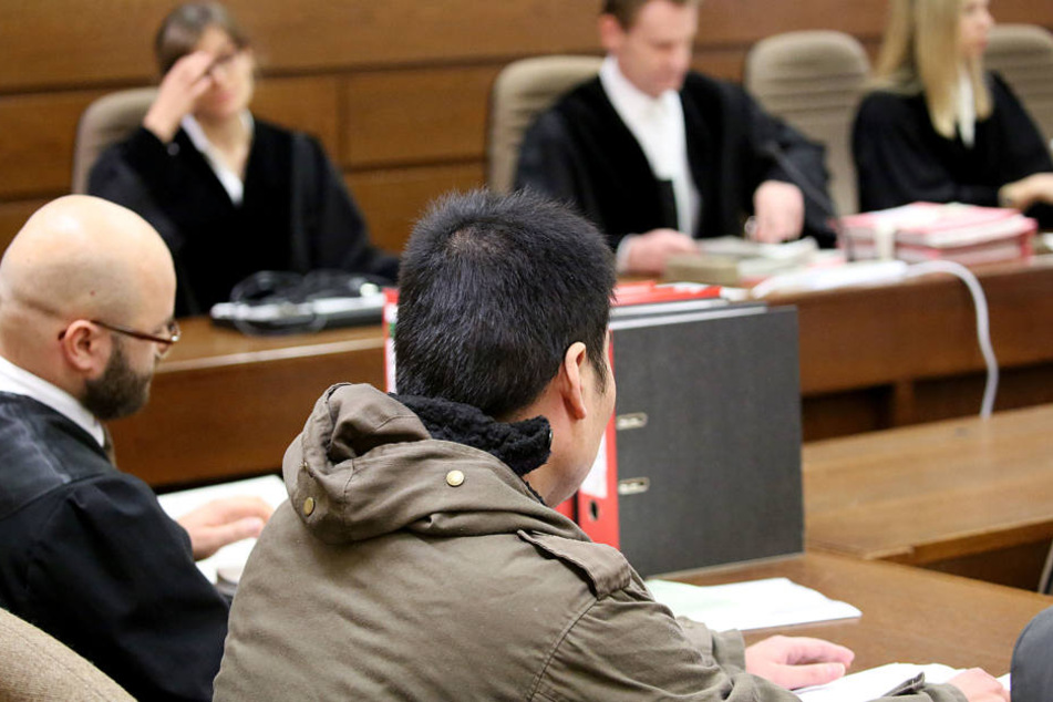 Der Angeklagte (r.) sitzt im Gerichtssaal neben seinem Anwalt.