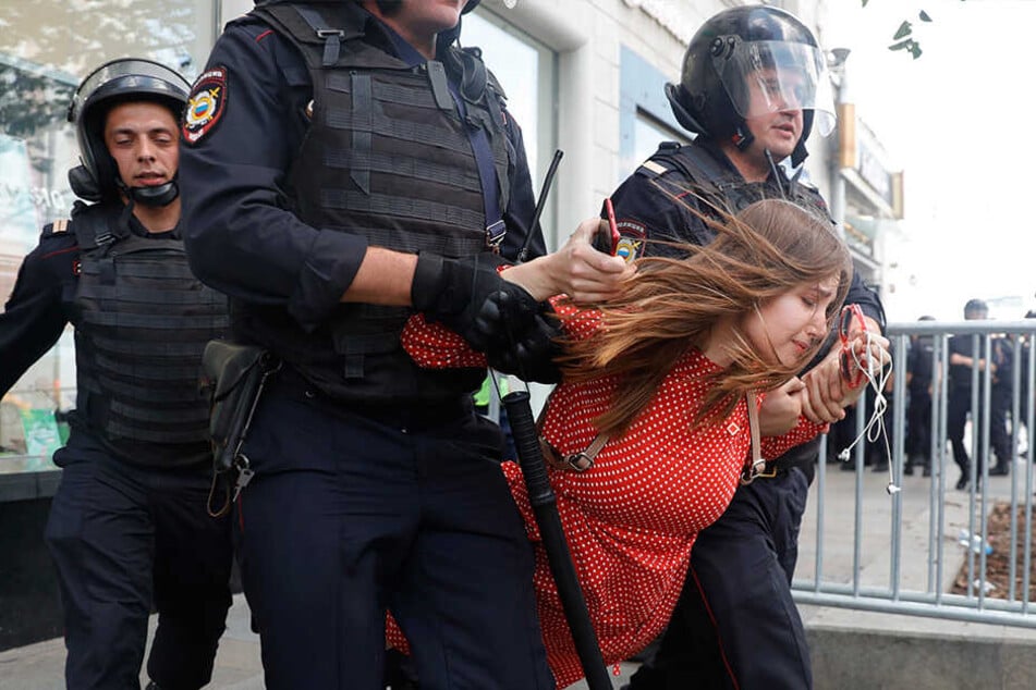 Polizisten führen eine Frau während der Protestaktion in Moskau ab.