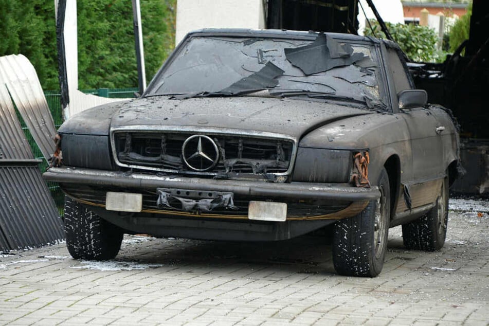 Der Mercedes SL 450 (Baujahr 1974) steht verrußt vor der ausgebrannten Garage von Steffen Lukas. Vom goldenen Lack ist kaum noch etwas zu sehen.