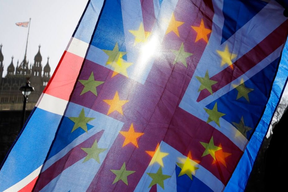 Ein Anti-Brexit-Aktivist schwenkt vor dem Parlament die Flaggen der Europäischen Union und Großbritanniens. (Archivbild)