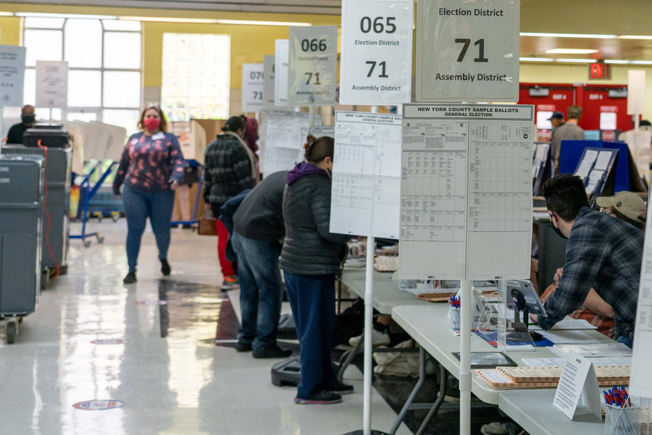 Poll workers wearing face masks check the voters Ids at a polling station in Manhattan, New York.