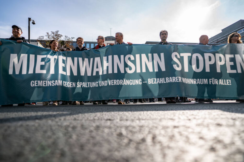 Hinter einem Transparent mit der Aufschrift "Mietenwahnsinn stoppen" ziehen Demonstranten durch die Frankfurter Innenstadt (Archivbild).