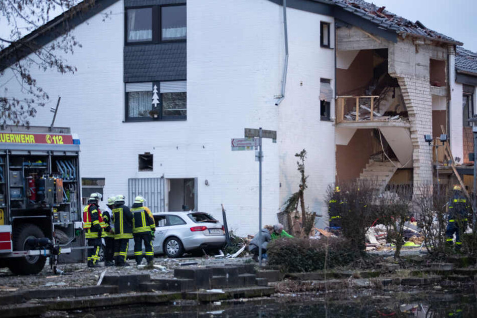 Feuerwehrleute und ein Einsatzfahrzeug der Feuerwehr am Unglücksort.
